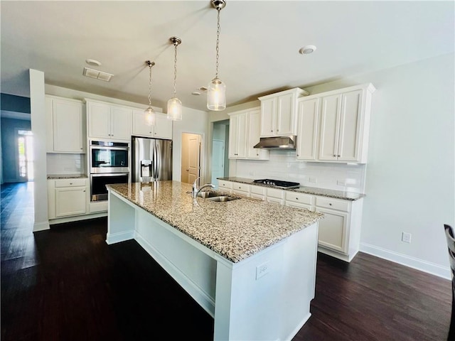 kitchen featuring sink, white cabinetry, hanging light fixtures, appliances with stainless steel finishes, and a kitchen island with sink