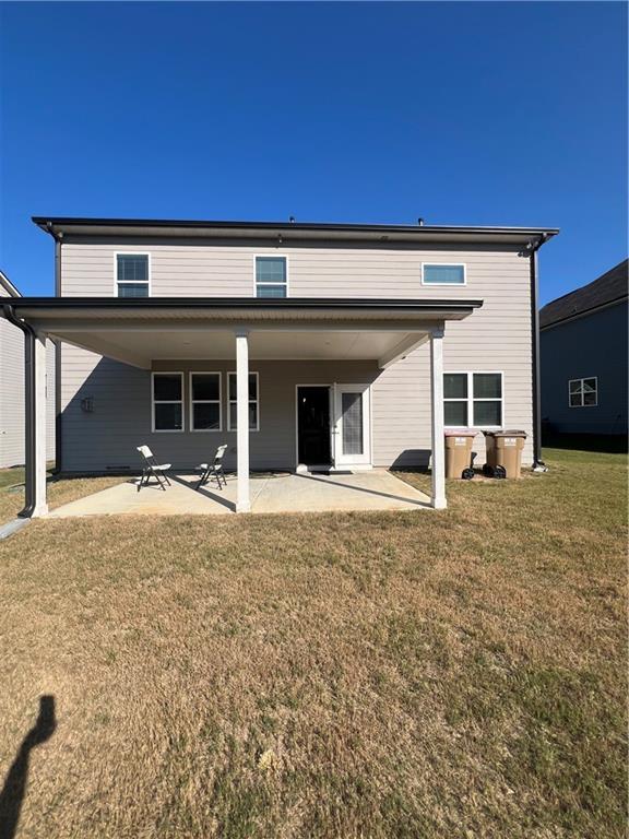 back of property featuring a yard and a patio