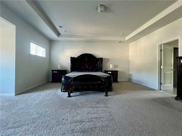 carpeted bedroom featuring a tray ceiling