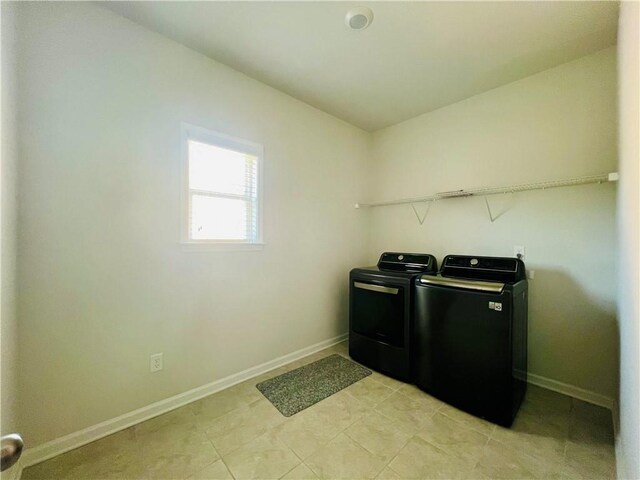 laundry area featuring light tile patterned floors and washing machine and clothes dryer