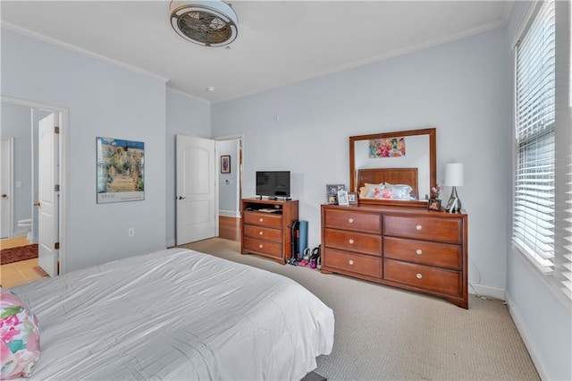 carpeted bedroom with ensuite bathroom and ornamental molding