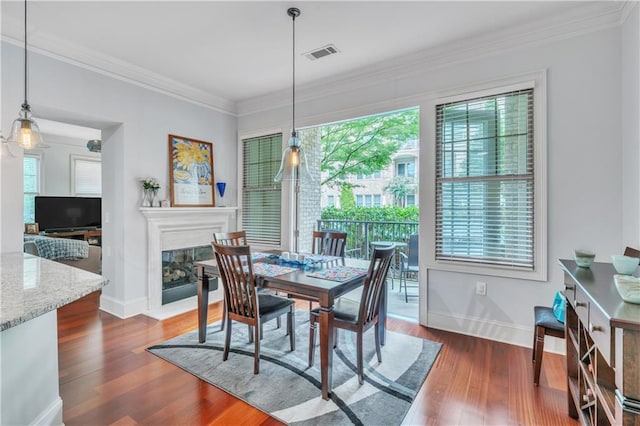 dining area featuring plenty of natural light, dark hardwood / wood-style floors, and ornamental molding