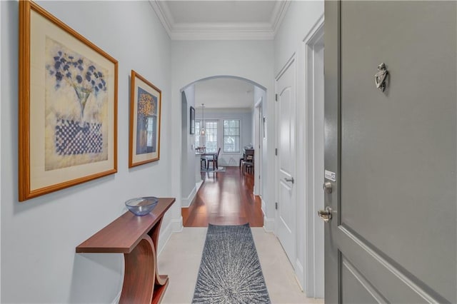 hallway featuring crown molding and light hardwood / wood-style flooring