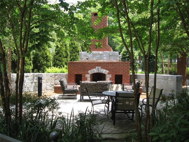 3621 Vinings Slope SE Unit 3202, Atlanta, GA 30339 - view of patio / terrace featuring an outdoor brick fireplace and fence