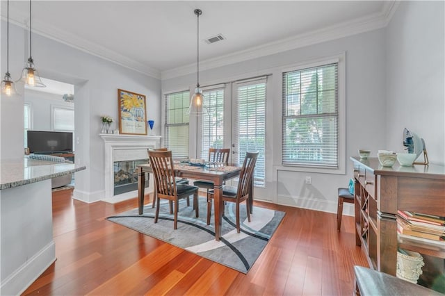 3621 Vinings Slope SE Unit 3202, Atlanta, GA 30339 - dining space with visible vents, baseboards, a glass covered fireplace, ornamental molding, and wood finished floors