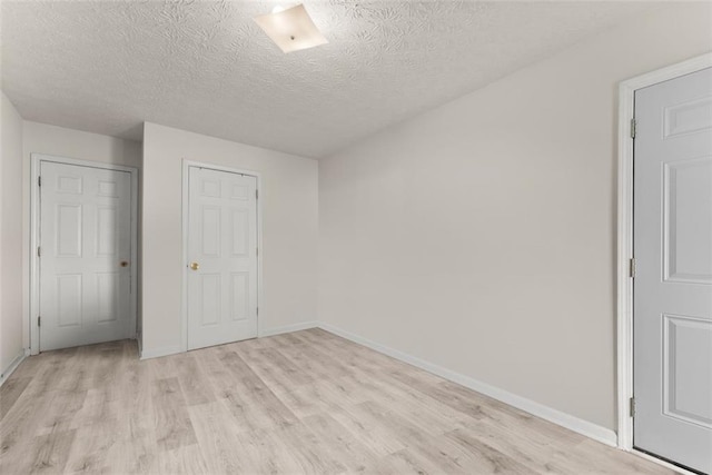 2428 Buena Vista Cir, Gainesville, GA 30504 - unfurnished bedroom featuring light wood-style flooring, a textured ceiling, and baseboards
