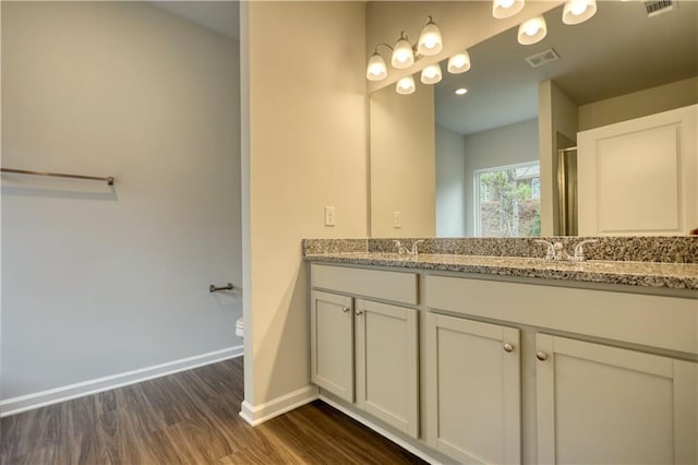 bathroom with vanity, toilet, and hardwood / wood-style floors