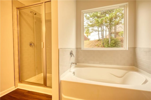 bathroom featuring plus walk in shower and hardwood / wood-style floors