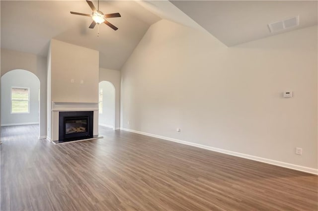 unfurnished living room with high vaulted ceiling, dark hardwood / wood-style floors, and ceiling fan