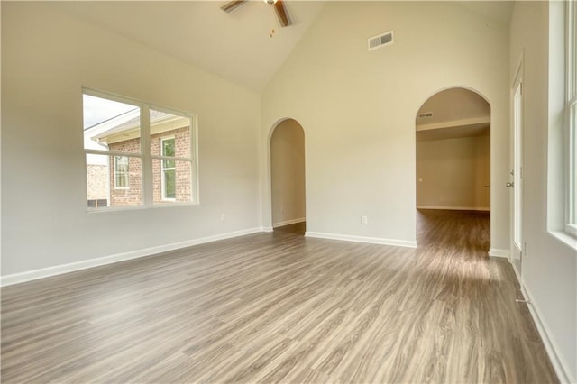 unfurnished room featuring high vaulted ceiling, hardwood / wood-style floors, and ceiling fan