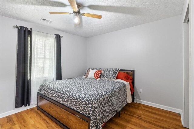 bedroom featuring a textured ceiling, hardwood / wood-style floors, and ceiling fan