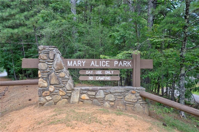 community / neighborhood sign with a view of trees
