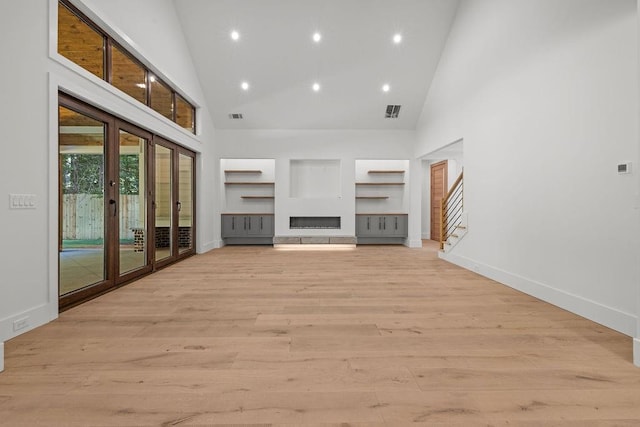 unfurnished living room with visible vents, recessed lighting, light wood-style flooring, and high vaulted ceiling