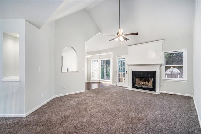 unfurnished living room with ceiling fan, vaulted ceiling, and carpet floors