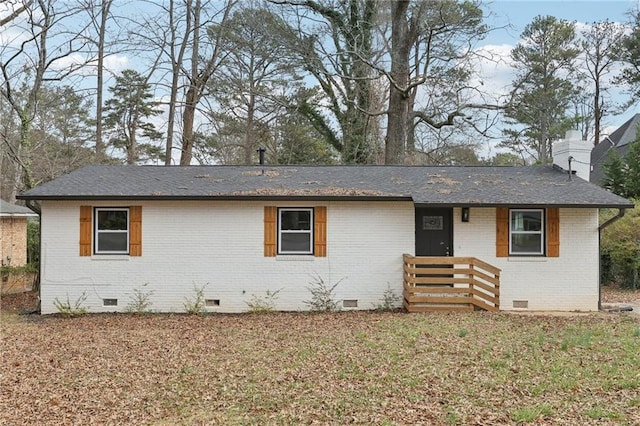 ranch-style house with a front yard, crawl space, brick siding, and a chimney