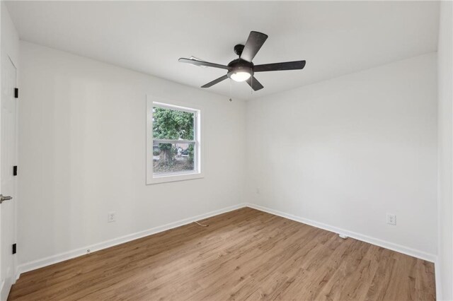 empty room featuring light wood-type flooring, ceiling fan, and baseboards