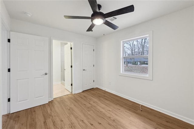 unfurnished bedroom with light wood finished floors, ceiling fan, visible vents, and baseboards