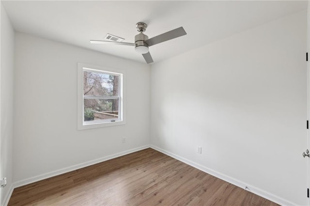 empty room featuring ceiling fan, baseboards, and wood finished floors