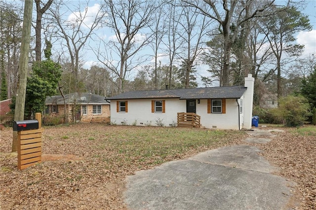 ranch-style home with brick siding, crawl space, and a chimney