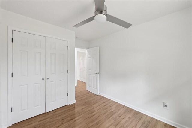 unfurnished bedroom with a ceiling fan, a closet, baseboards, and wood finished floors