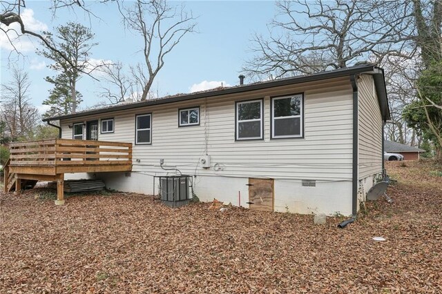 rear view of property with crawl space, cooling unit, and a wooden deck