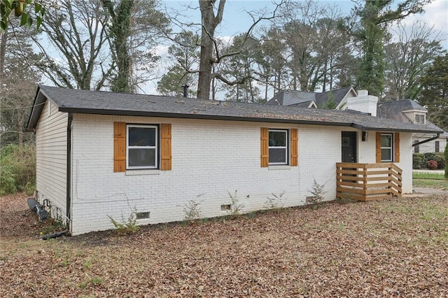 ranch-style home featuring crawl space, brick siding, and a chimney