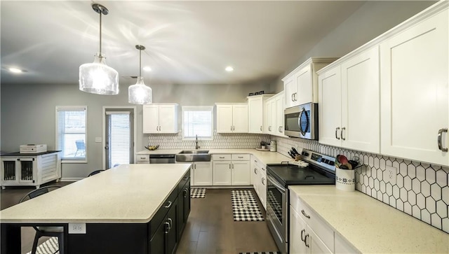 kitchen with pendant lighting, a center island, white cabinets, and appliances with stainless steel finishes