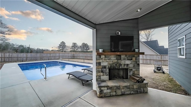 view of swimming pool featuring an outdoor stone fireplace and a patio