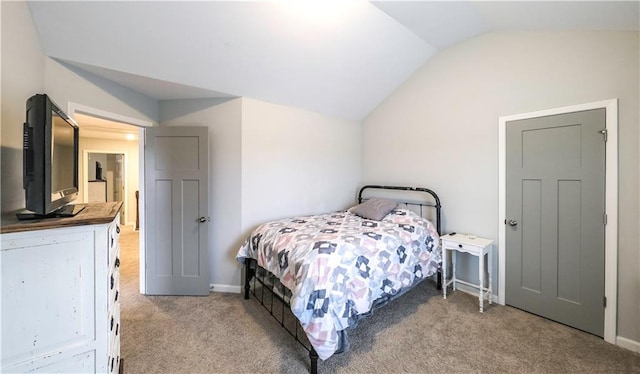 bedroom featuring light carpet and vaulted ceiling