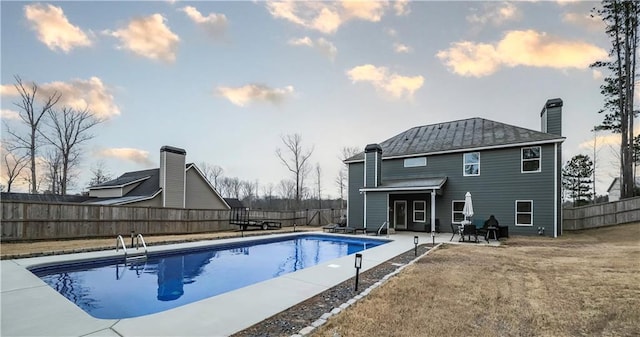 pool at dusk featuring a patio