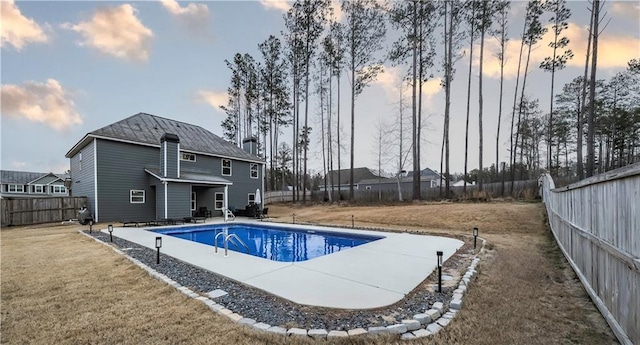 pool at dusk with a patio area