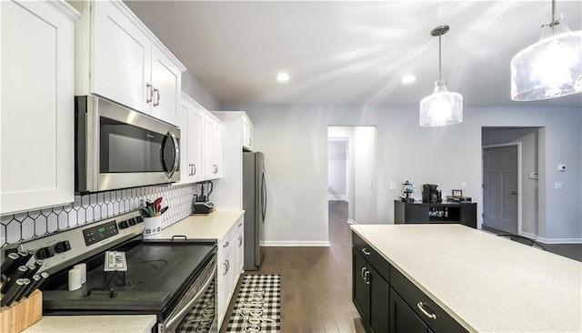 kitchen featuring dark hardwood / wood-style flooring, pendant lighting, white cabinets, and stainless steel appliances