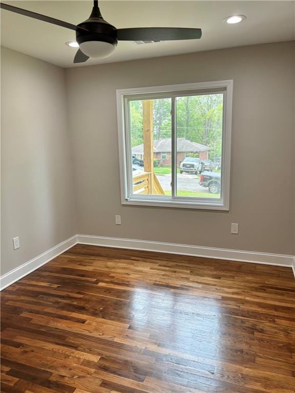 empty room featuring dark wood-type flooring and ceiling fan