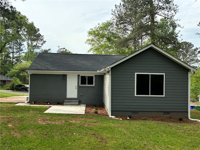 back of property with entry steps, a shingled roof, a yard, crawl space, and a patio area