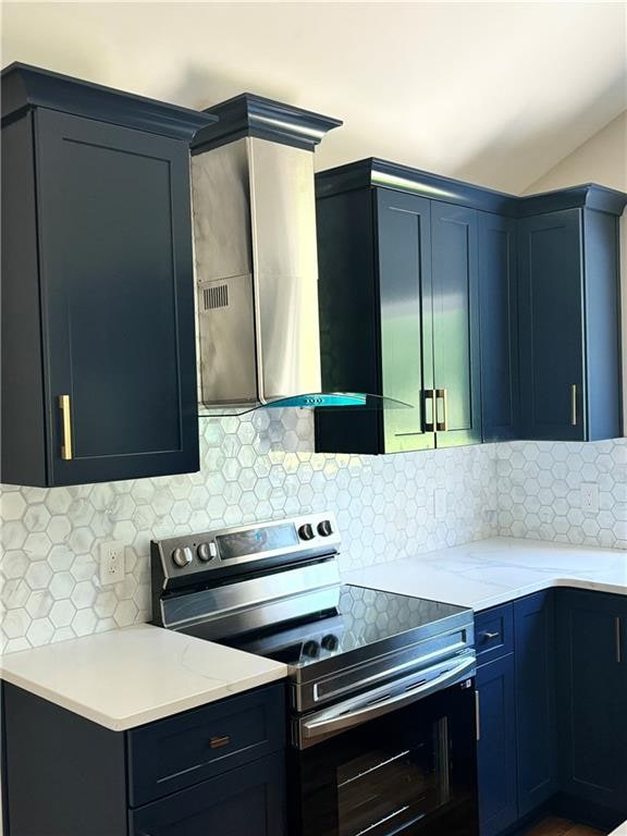 kitchen with electric range, wall chimney exhaust hood, and tasteful backsplash