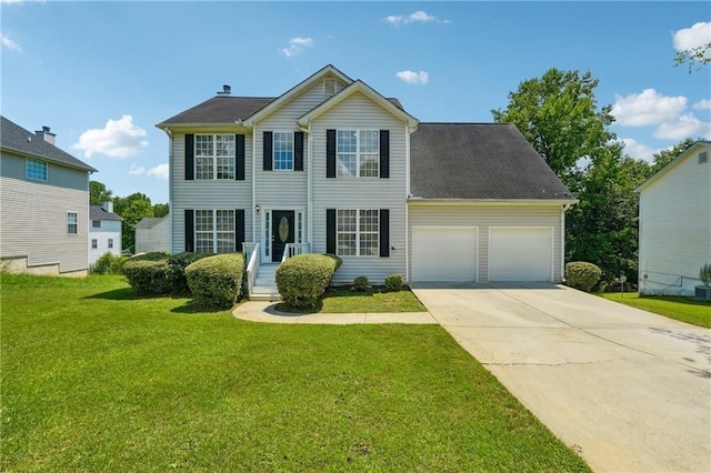 colonial inspired home with a front lawn and a garage