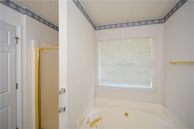 bathroom with independent shower and bath and a textured ceiling