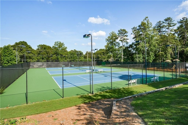 view of tennis court with a lawn