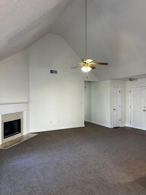 unfurnished living room featuring ceiling fan, vaulted ceiling, and dark colored carpet