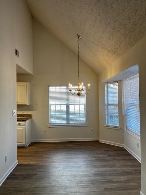 unfurnished dining area featuring a notable chandelier, dark hardwood / wood-style floors, a textured ceiling, and high vaulted ceiling