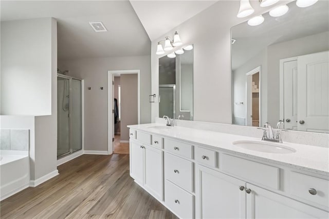 4172 Cedar Commons Way, Conley, GA 30288 - bathroom with a stall shower, double vanity, a bath, wood finished floors, and baseboards