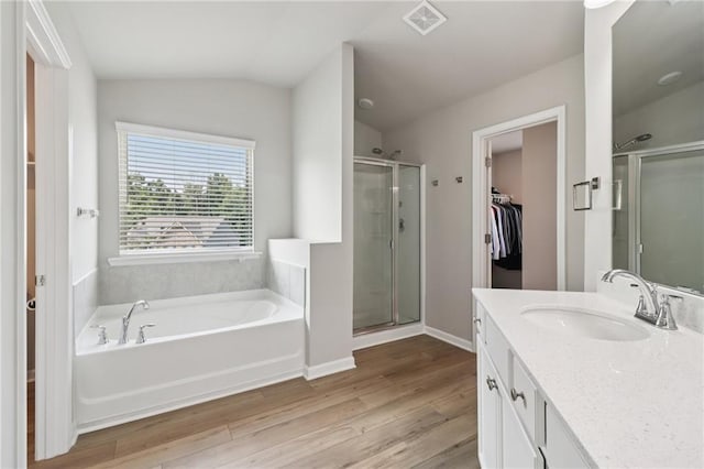 4172 Cedar Commons Way, Conley, GA 30288 - full bathroom featuring a stall shower, vanity, a garden tub, wood finished floors, and a walk in closet