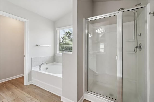 4172 Cedar Commons Way, Conley, GA 30288 - bathroom featuring a stall shower, vaulted ceiling, wood finished floors, a garden tub, and baseboards