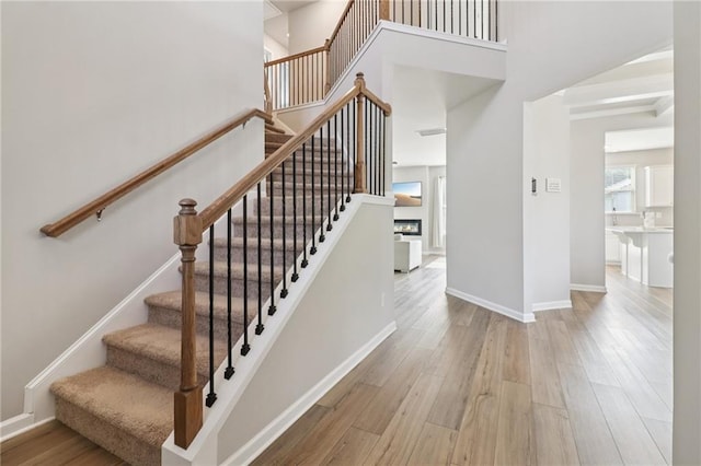4172 Cedar Commons Way, Conley, GA 30288 - staircase featuring a towering ceiling, wood finished floors, and baseboards