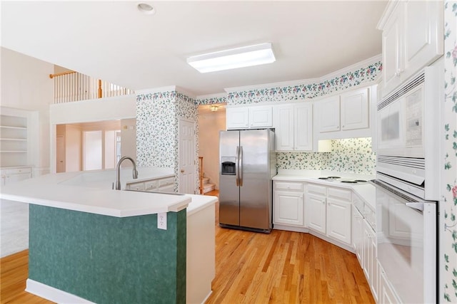 kitchen featuring white cabinets, decorative backsplash, white appliances, and light hardwood / wood-style flooring