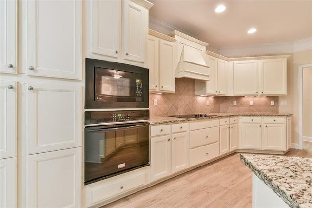 6714 Amherst Dr, Hoschton, GA 30548 - kitchen featuring black appliances, custom exhaust hood, light wood-style flooring, decorative backsplash, and light stone countertops