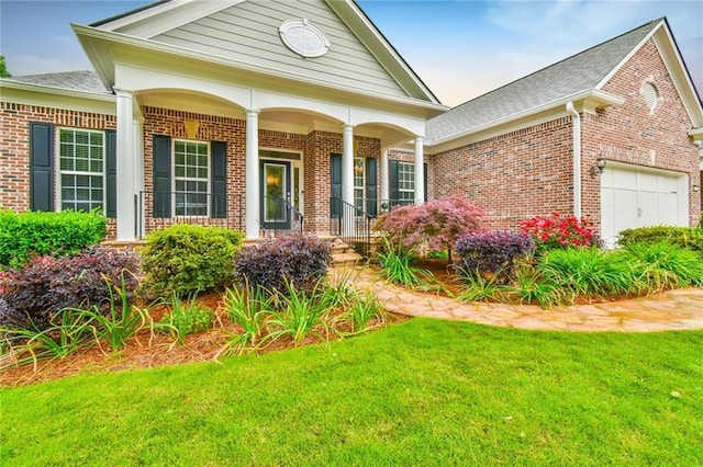 6714 Amherst Dr, Hoschton, GA 30548 - view of front of property with brick siding, an attached garage, a front lawn, covered porch, and a shingled roof