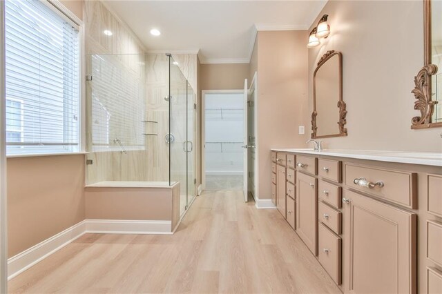 6714 Amherst Dr, Hoschton, GA 30548 - bathroom with double vanity, a shower stall, wood finished floors, ornamental molding, and a spacious closet