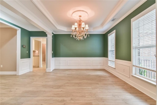 6714 Amherst Dr, Hoschton, GA 30548 - unfurnished room with a raised ceiling, a chandelier, light wood-type flooring, a wainscoted wall, and ornamental molding