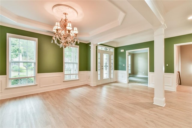 6714 Amherst Dr, Hoschton, GA 30548 - foyer with decorative columns, a chandelier, light wood-type flooring, a wainscoted wall, and ornamental molding
